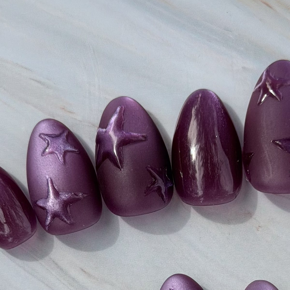 Violet Stars press-on nails, close-up of the hand-painted detail